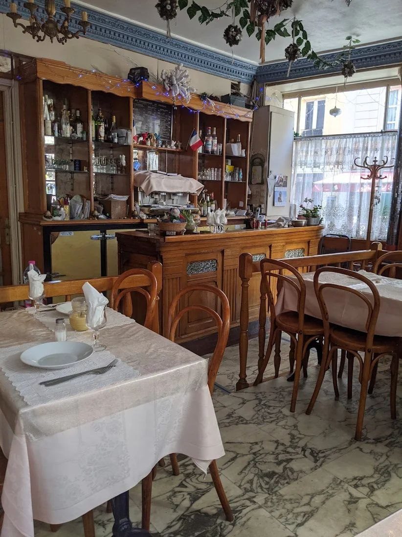 Salle du restaurant Chez Lucette : bar en bois, tables nappées, ambiance de bistro traditionnel